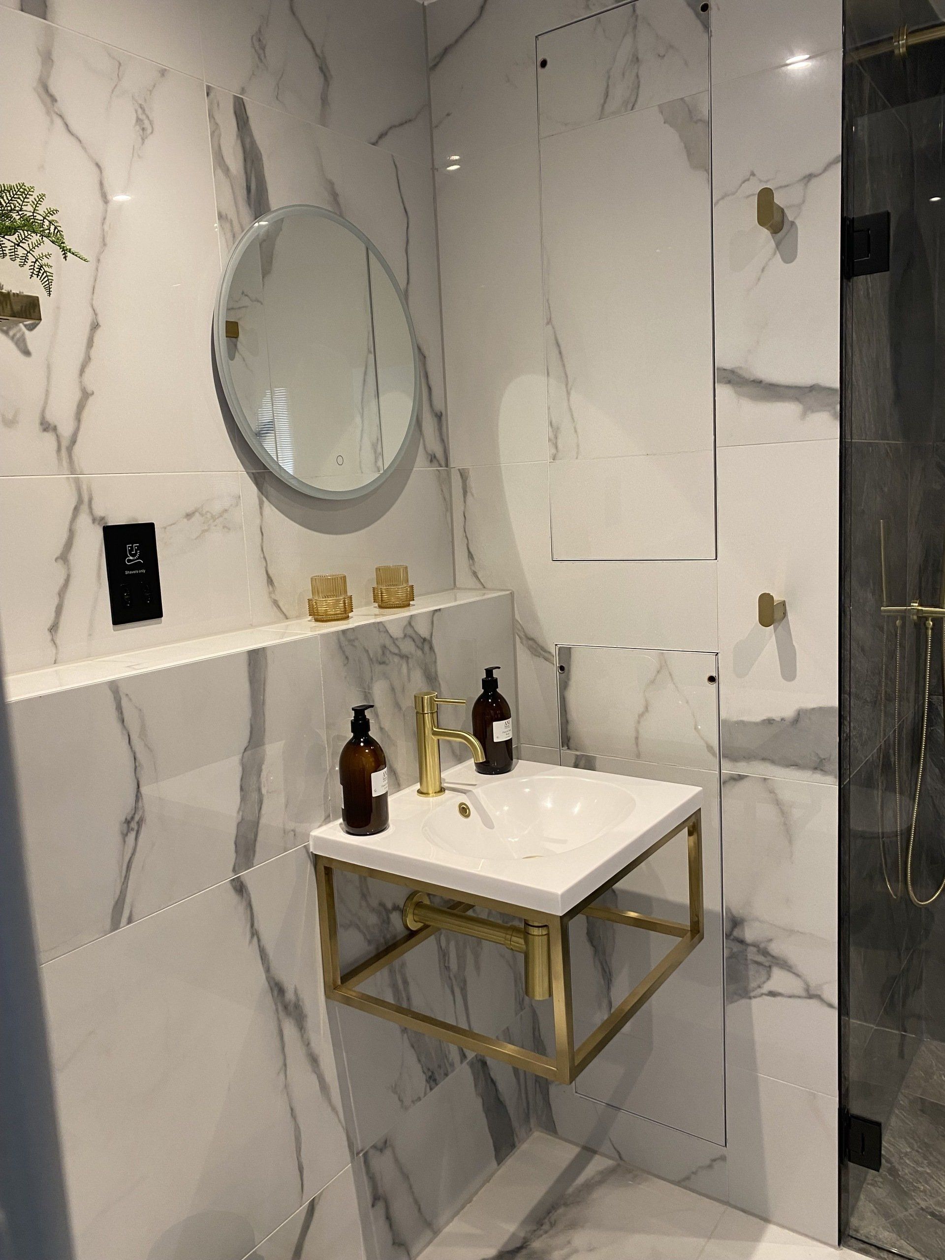 A bathroom with a sink , mirror and shower.