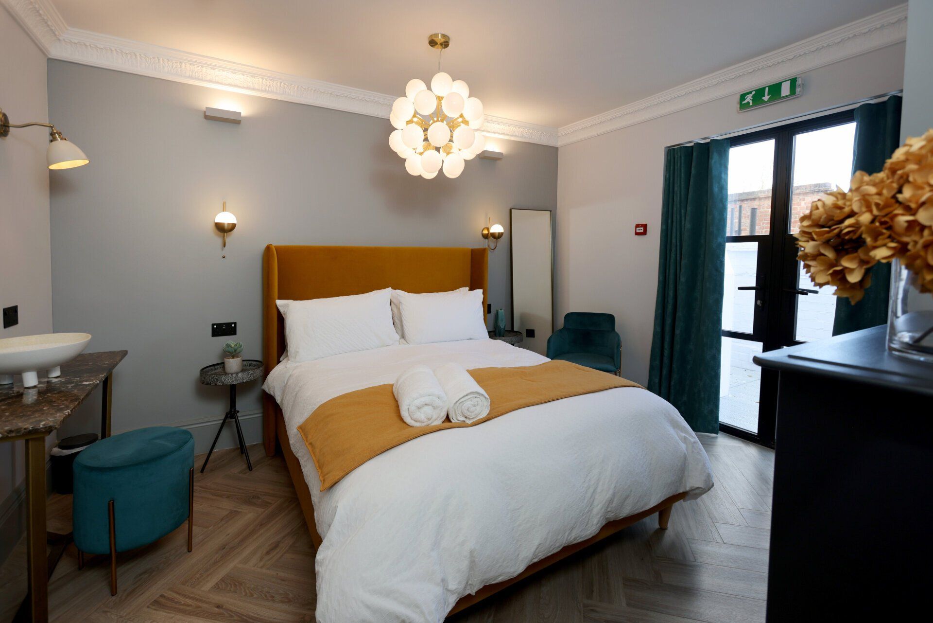 Neptune Apartments luxury apartment inside view, large bed dressed in white linen with mustard blanket