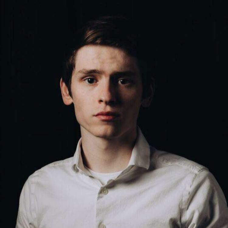 Portrait of a man in a white shirt against a dark background