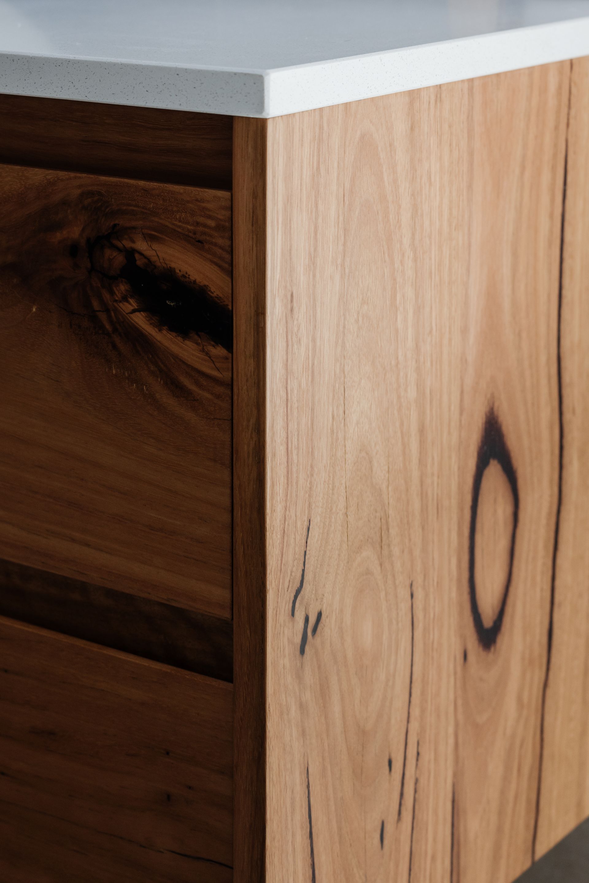 Wooden bathroom vanity with white countertop.