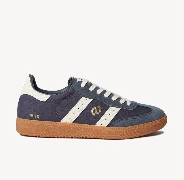 Blue sneakers with white stripes and a brown sole.