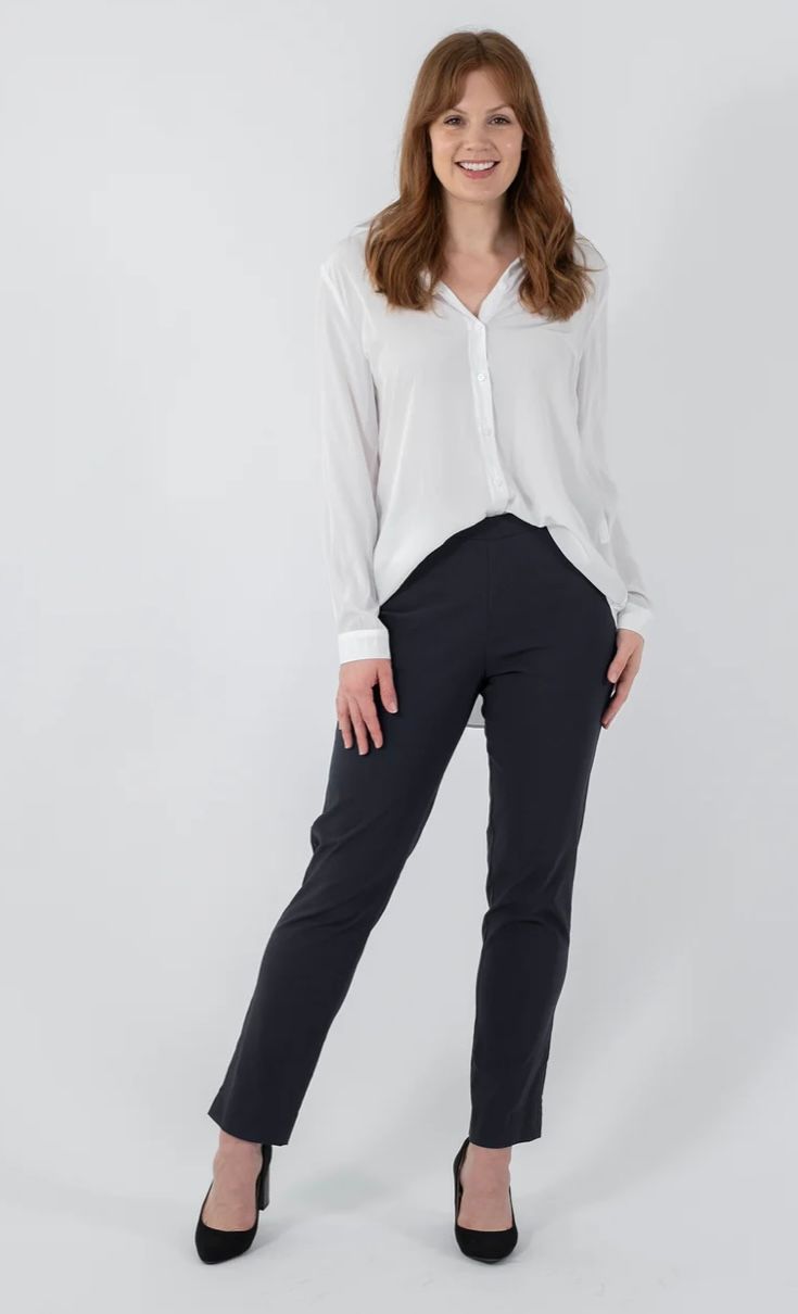 Woman in White Blouse and Navy Pants, Smiling, Posing Against a White Backdrop — Onyx Poppy Boutique in Buderim, QLD