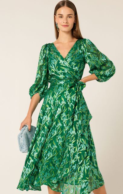 A Woman is Wearing a Green Floral Dress and Holding a Clutch — Onyx Poppy Boutique in Buderim, QLD