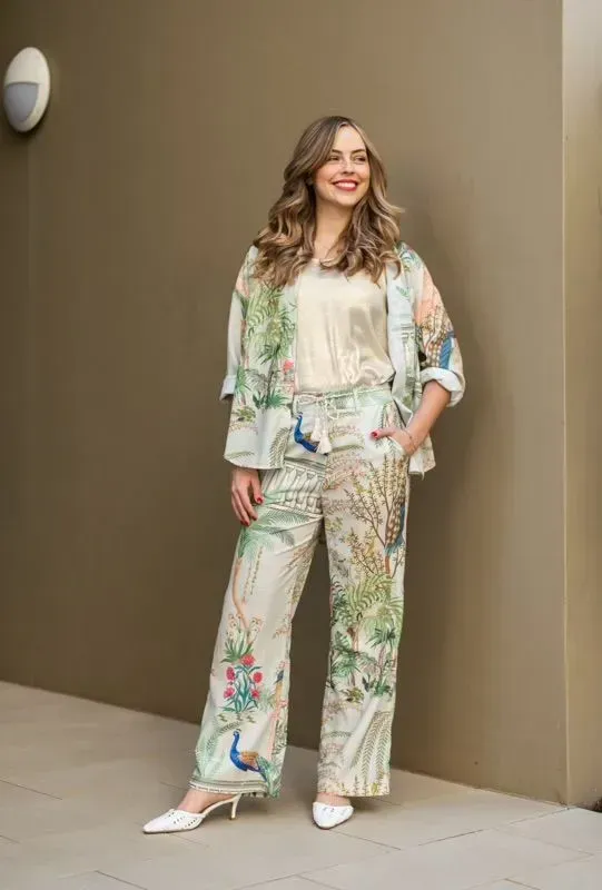 A Woman is Standing in Front of a Wall Wearing a Floral Suit — Onyx Poppy Boutique in Sunshine Coast, QLD
