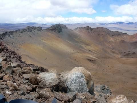 Mirador en las Montañas Rocosas, con un amplio valle marrón y un cielo nublado a lo lejos