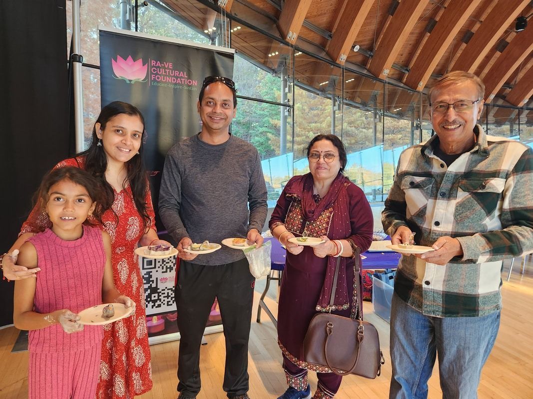 Five people hold up food in a building with large windows.