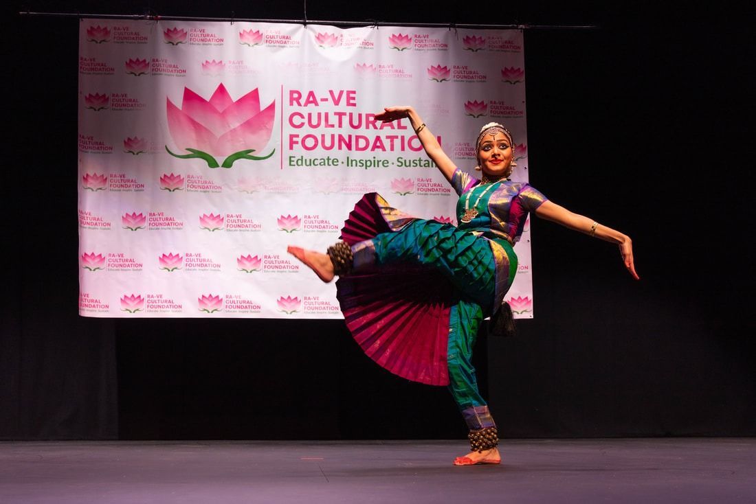 Woman in traditional Indian dance costume performing on stage.