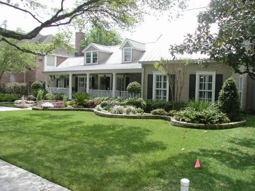 A large house with a porch and a lush green lawn
