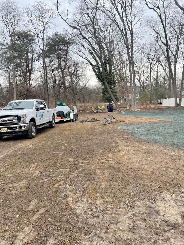 A couple of trucks are parked in a dirt lot.