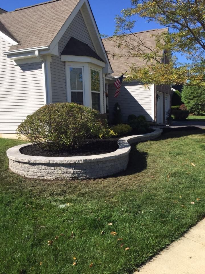 A white house with a large planter in front of it.