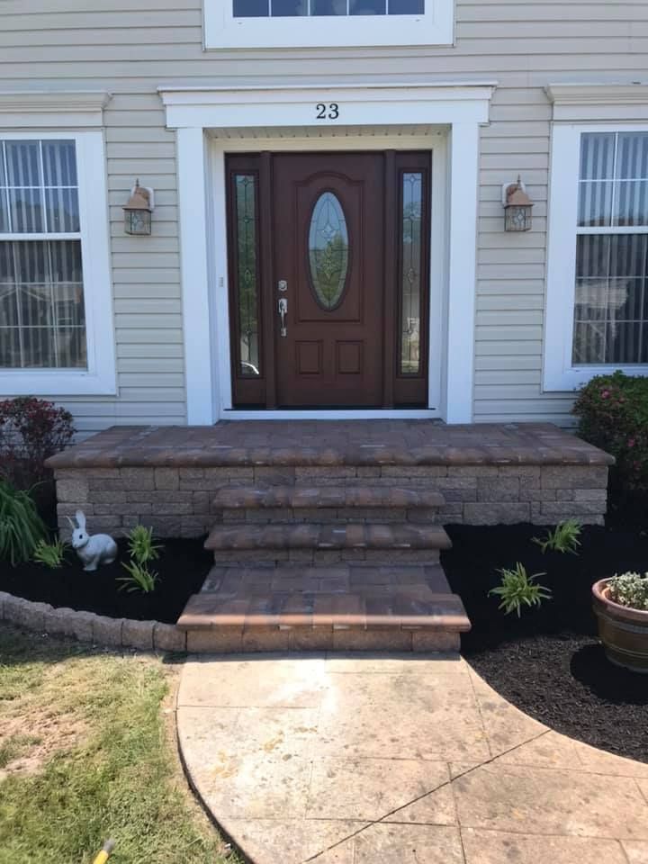 The front door of a house with a brick walkway leading to it.