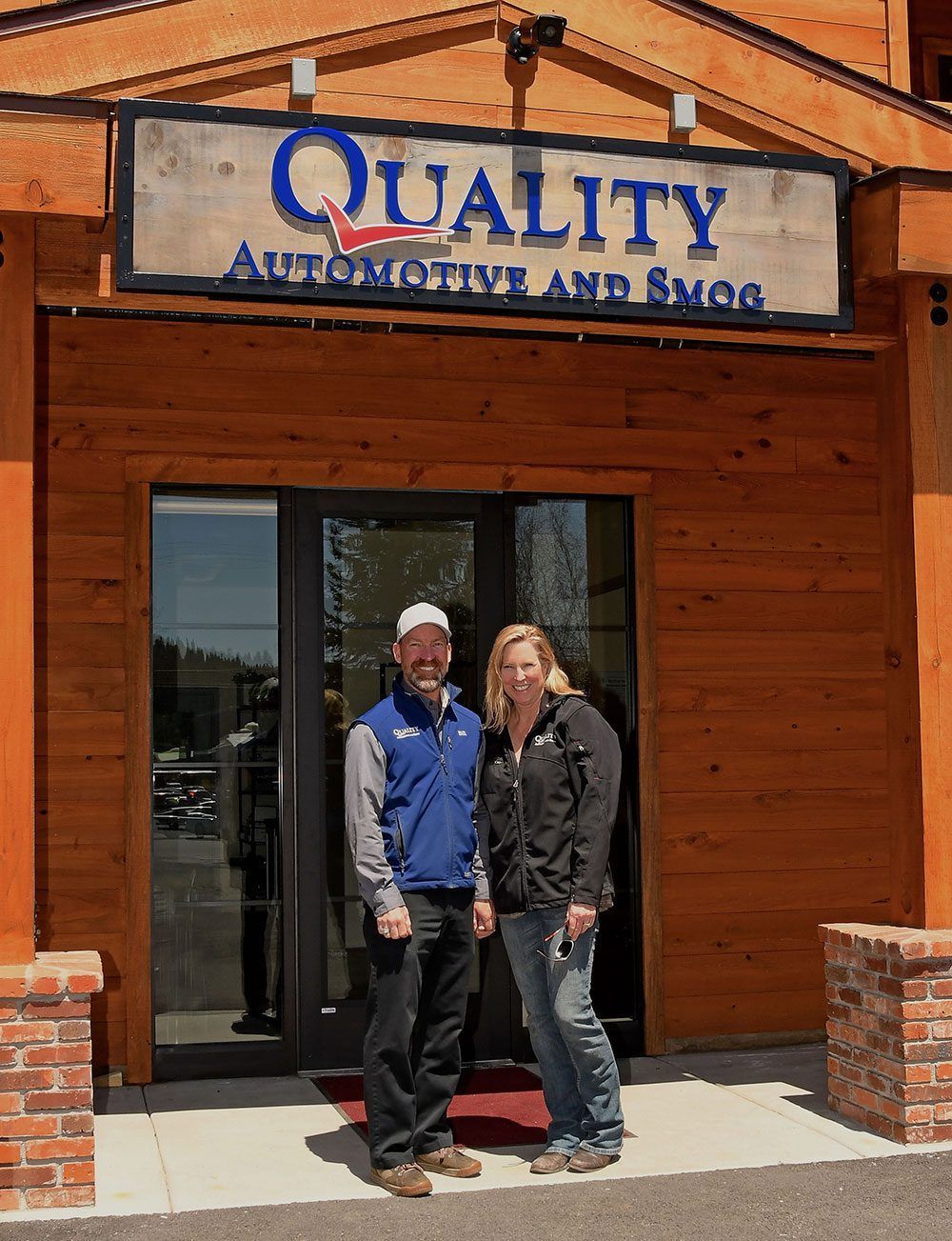 Two people standing at the entrance of Quality Automotive and Brake shop | Quality Automotive Servicing