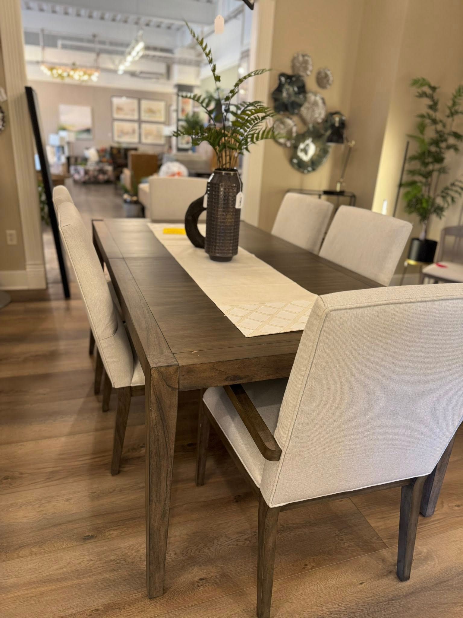 Dining table with woven chairs and centerpiece in a bright, open-concept living and dining room