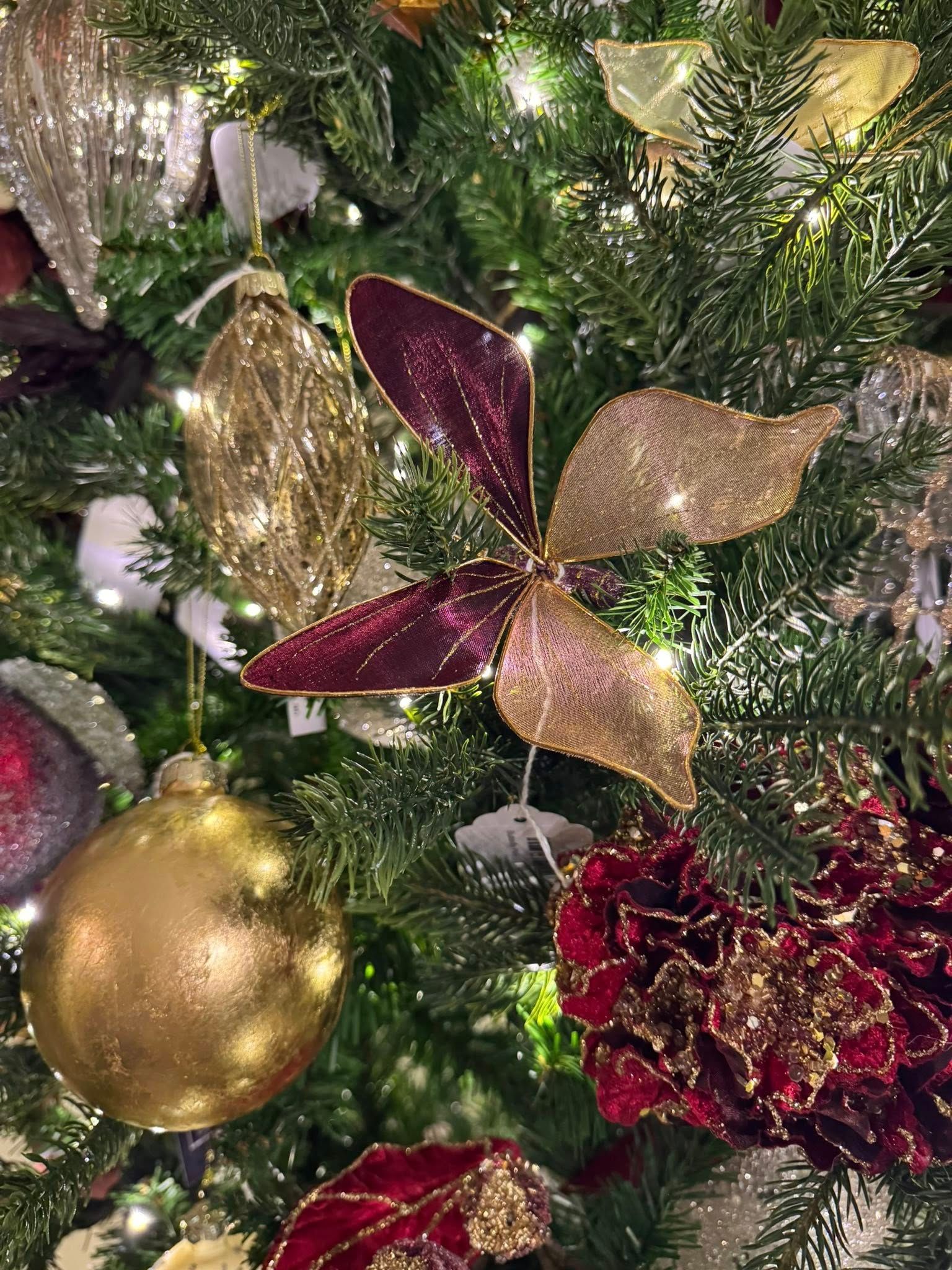 Christmas tree with gold and red ornaments, glittery poinsettia, and shiny decorations