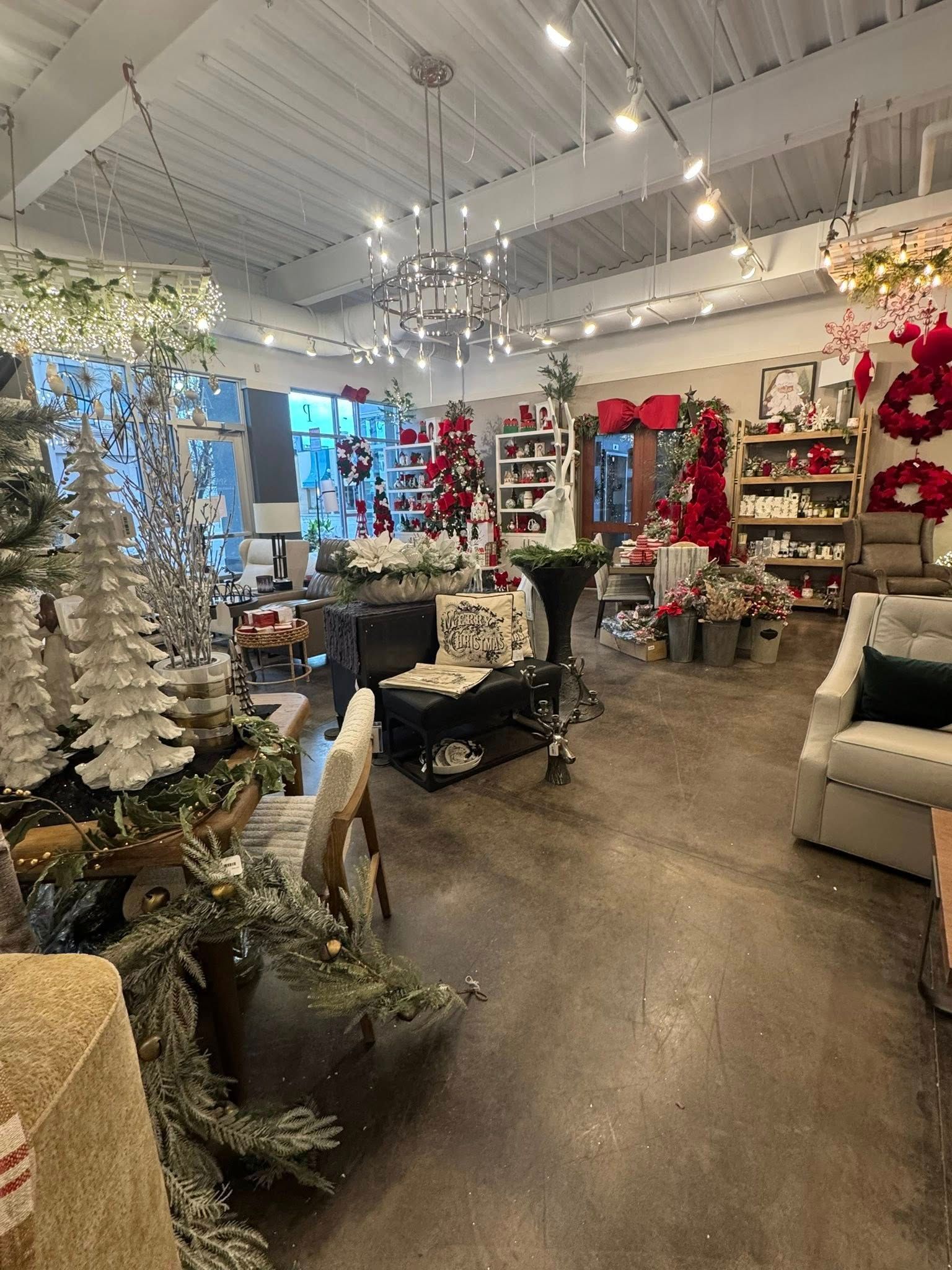 Bright floral shop interior with white decor, plants, chairs, and shelves of flowers and gifts