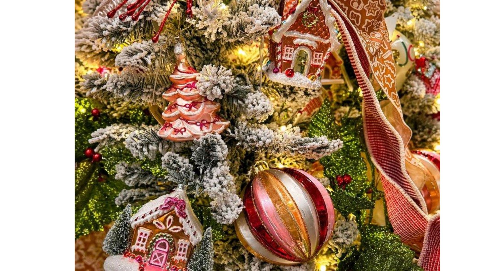 Snow-dusted Christmas tree with red-and-gold ornaments and ribbon decorations