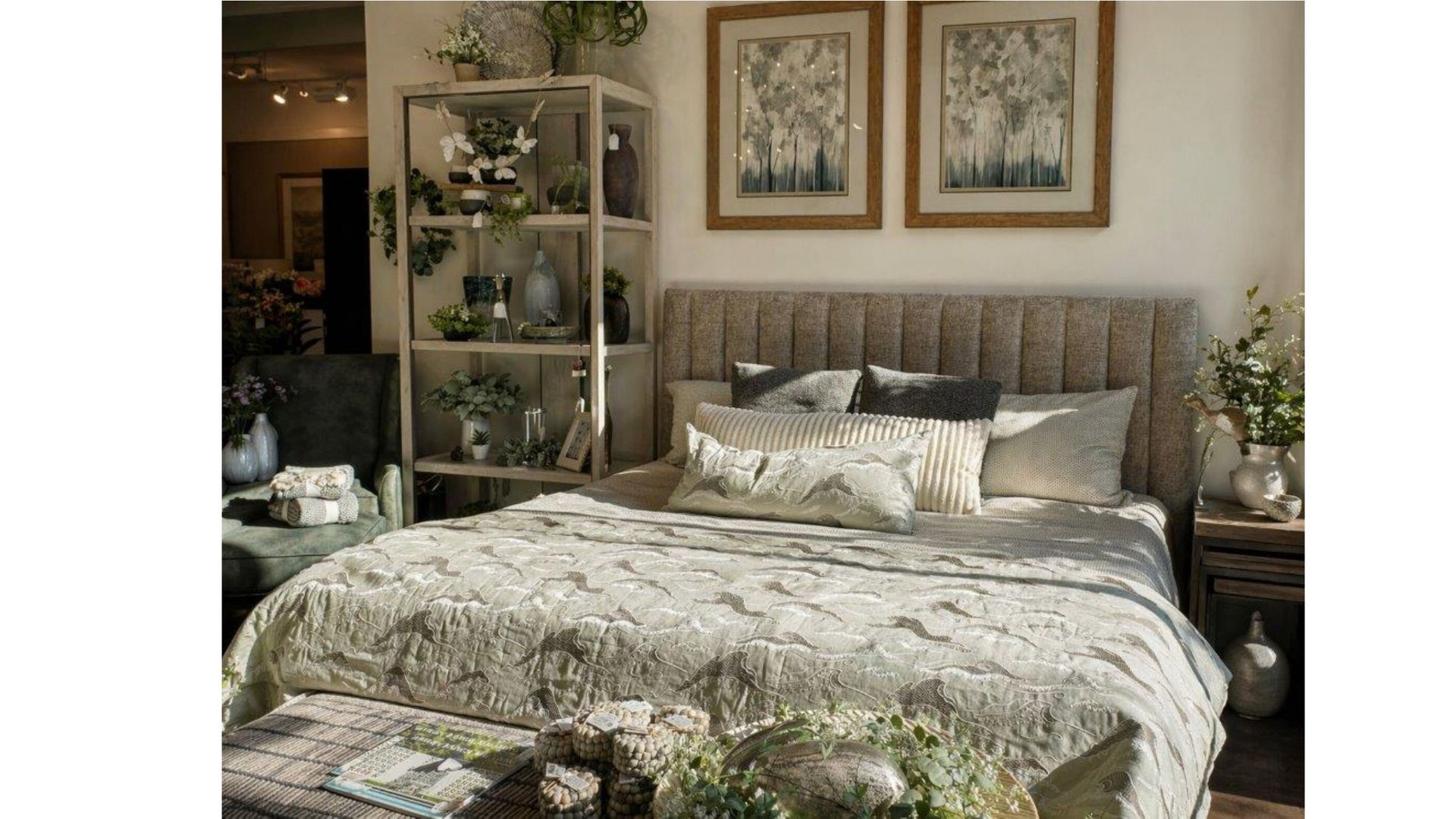 Cozy bedroom with a tufted bed, neutral bedding, wall art, and a shelf of plants and decor