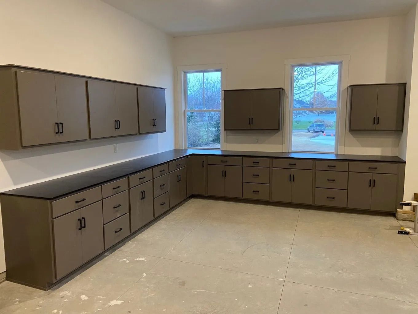 Garage with brown cabinets and black countertops.