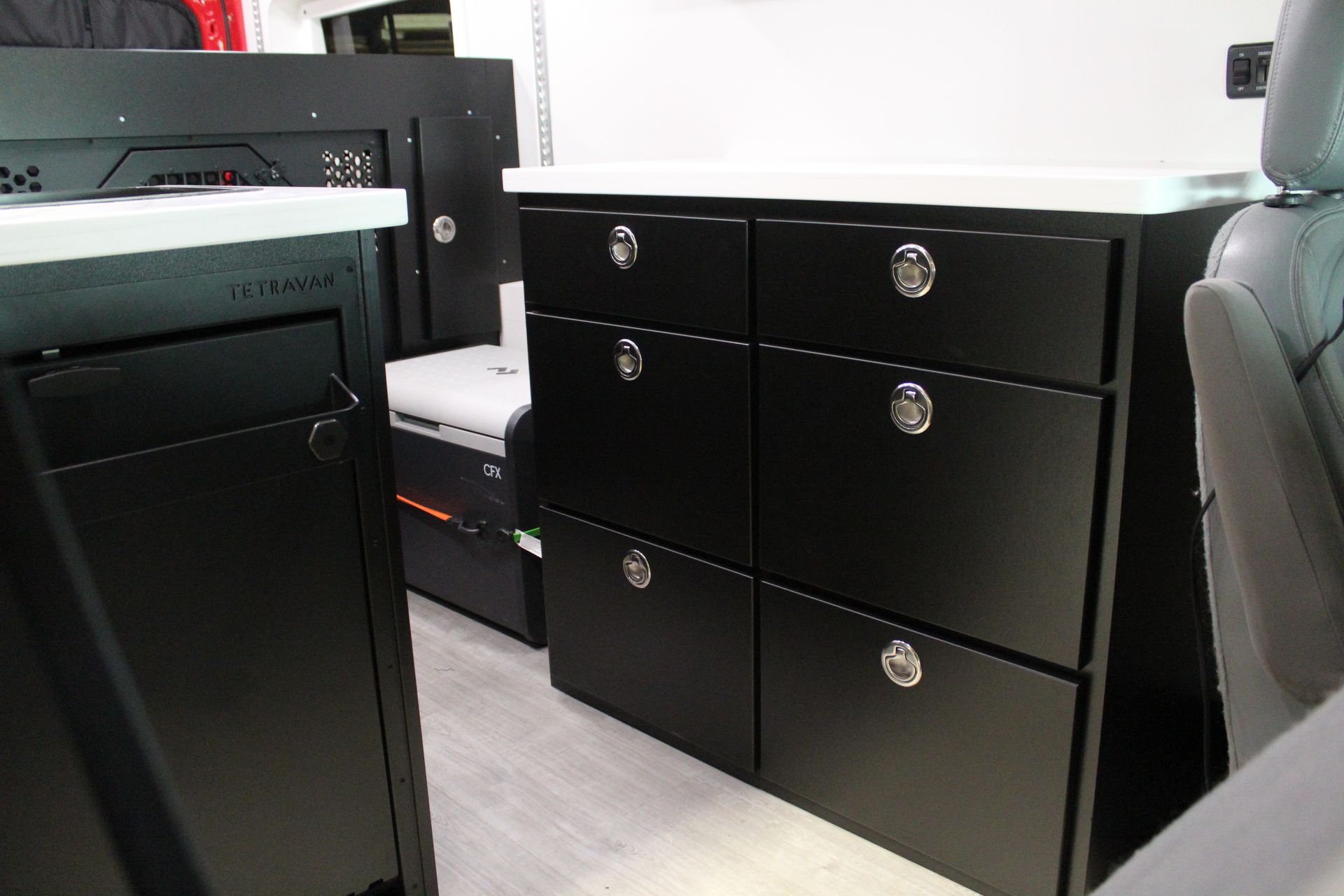 Black cabinets with silver handles inside a camper van.