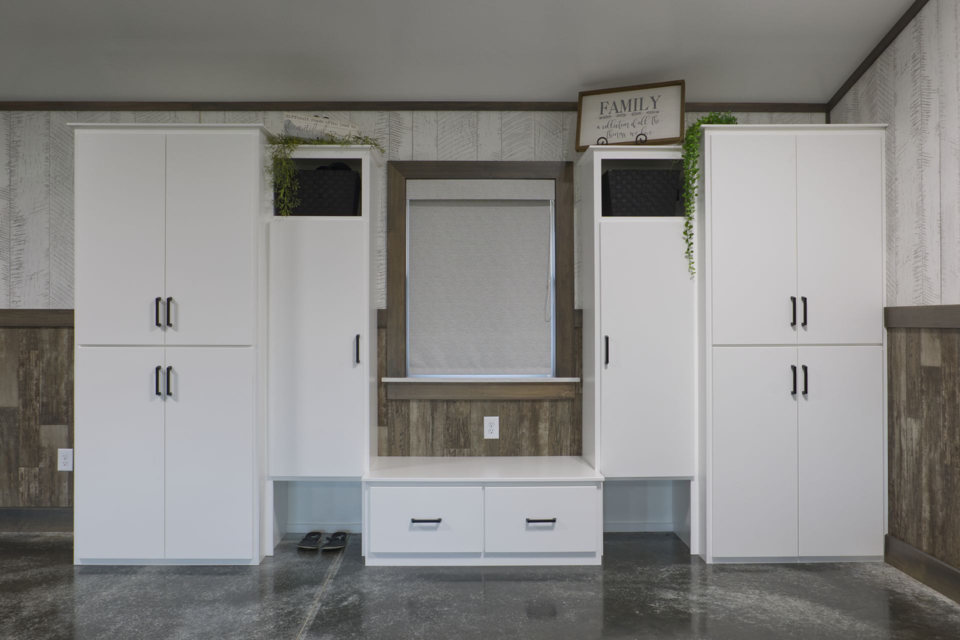 White storage cabinets with a bench and mirror in a room.