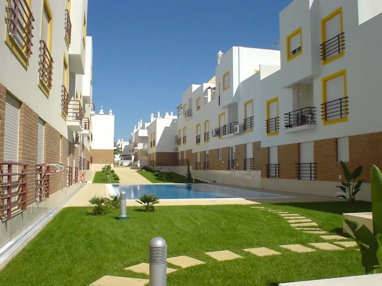 Impression of Apartment Mar, with green grass and pool and surrounded by apartments.