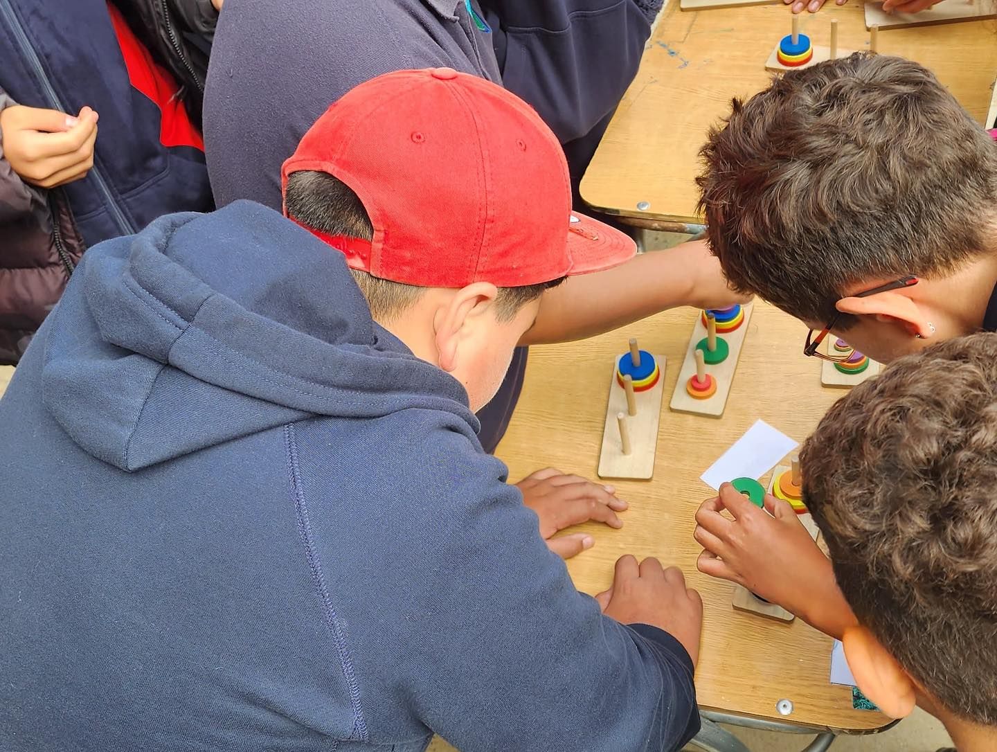 Niños jugando con coloridos juguetes apilables sobre una mesa.