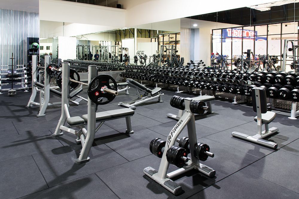 A Well-equipped Gym With Grey Flooring and Mirrors Reflect the Equipment — AGM Flooring & Tiling in Hidden Valley, QLD