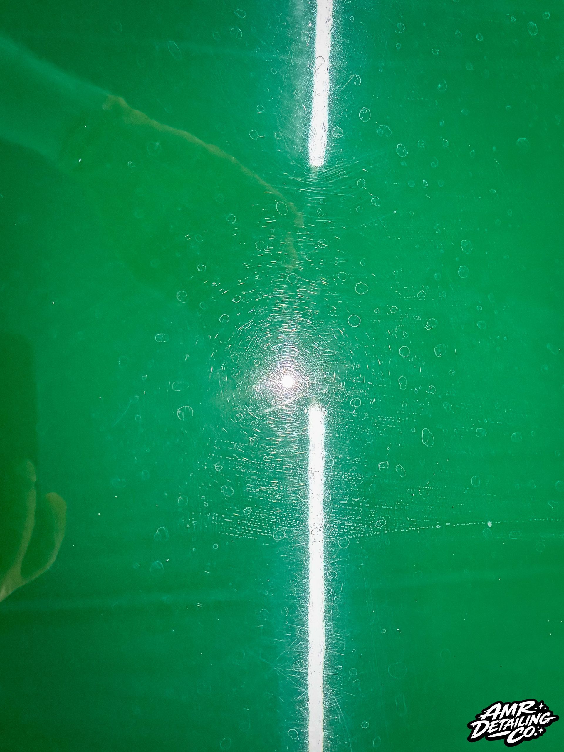 Green surface with a bright vertical white line and a small glittery burst near the center