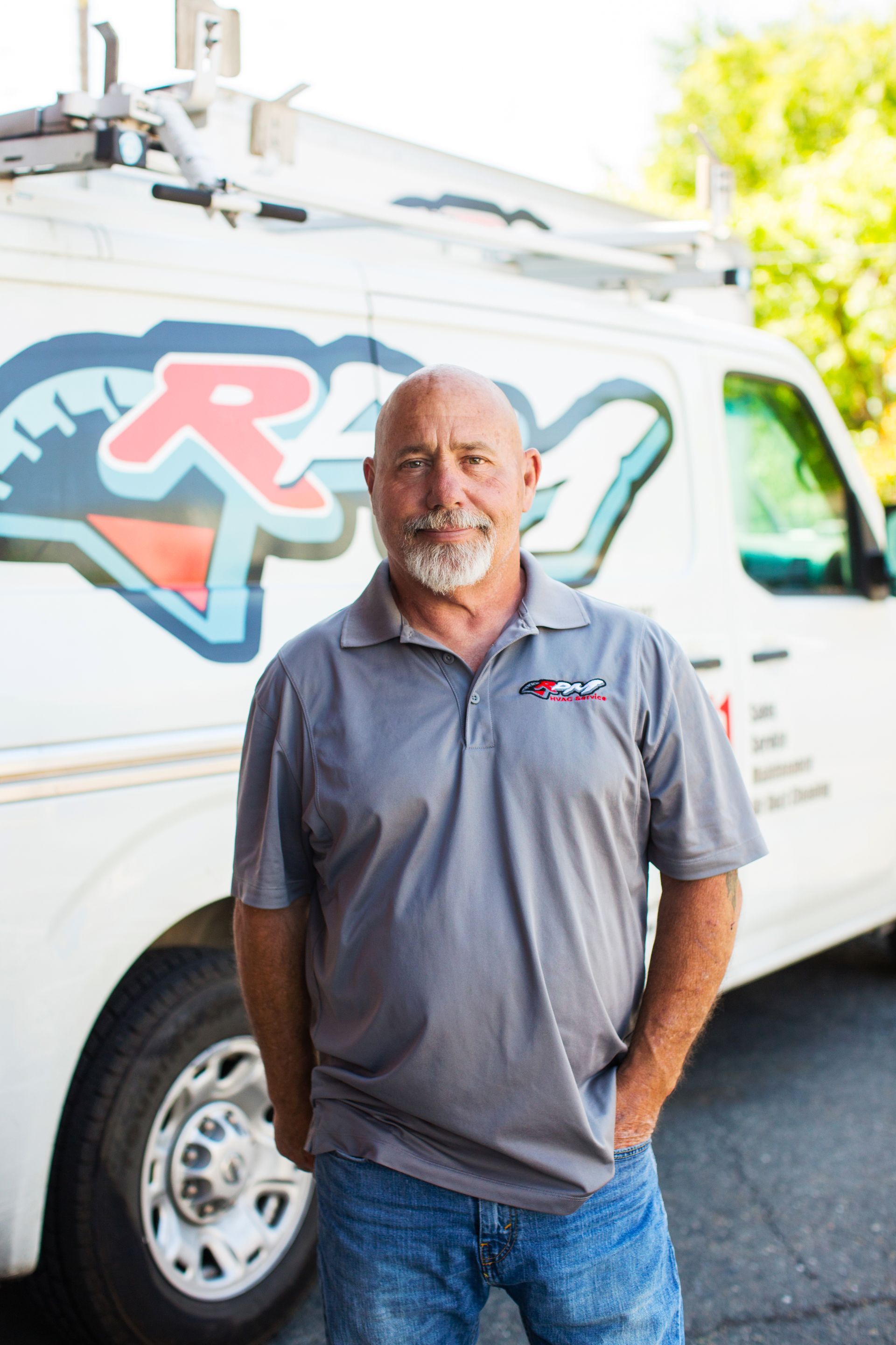 HVAC technician standing in front of RPM HVAC service van, specializing in air conditioning repair and heating service