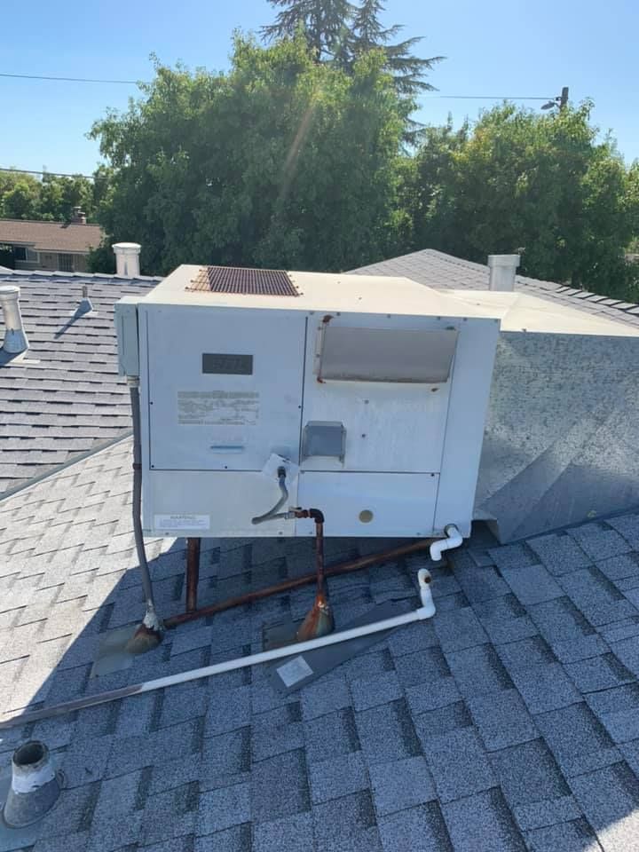 Rear view of weathered rooftop HVAC unit.
