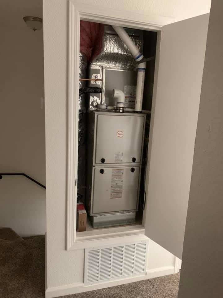 Indoor furnace system in closet with PVC vent piping.