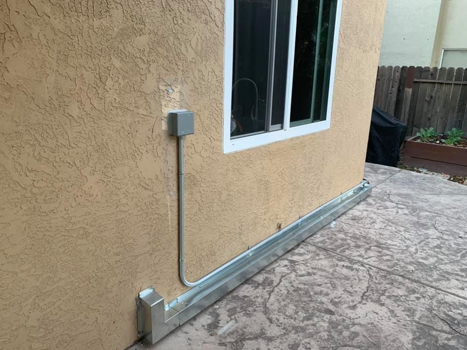 Finished line set chase and conduit installation along stucco wall by RPM HVAC Service Inc.
