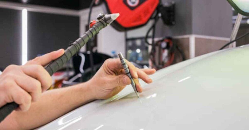 Dentist using tools to work on a tooth model on a white surface