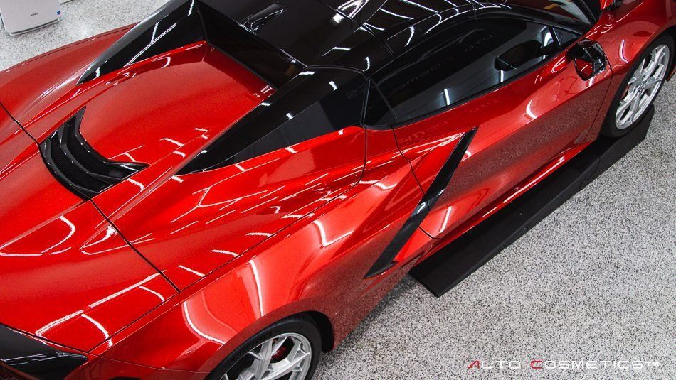 Red sports car with black roof viewed from above in a parking lot