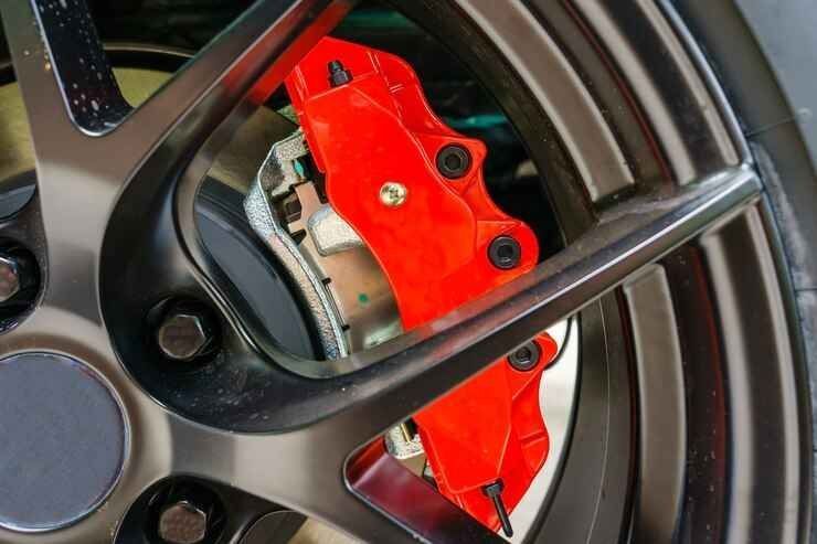 Red brake caliper behind a black alloy wheel rim.