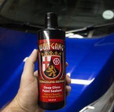 Bottle of Wolfgang Concours Series Deep Gloss Paint Sealant on a car hood backdrop