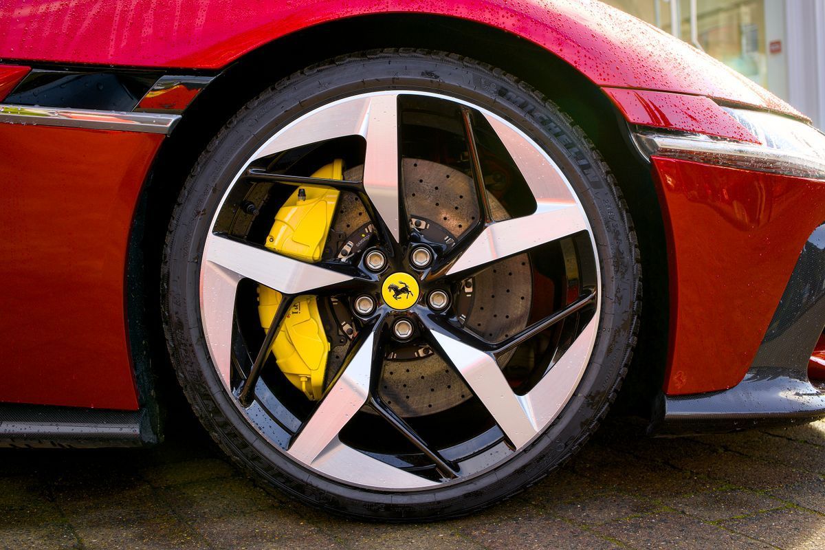 Painted yellow brake calipers on a red sports car