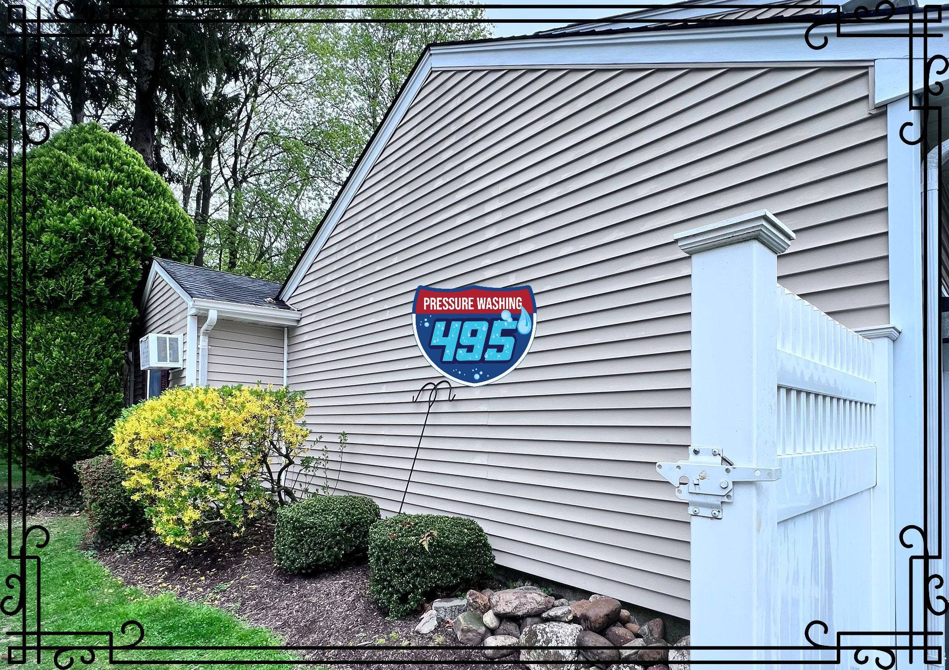 Side of a light-colored house with a sign displaying