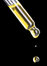 Close-up of a glass dropper releasing clear liquid droplets on a black background