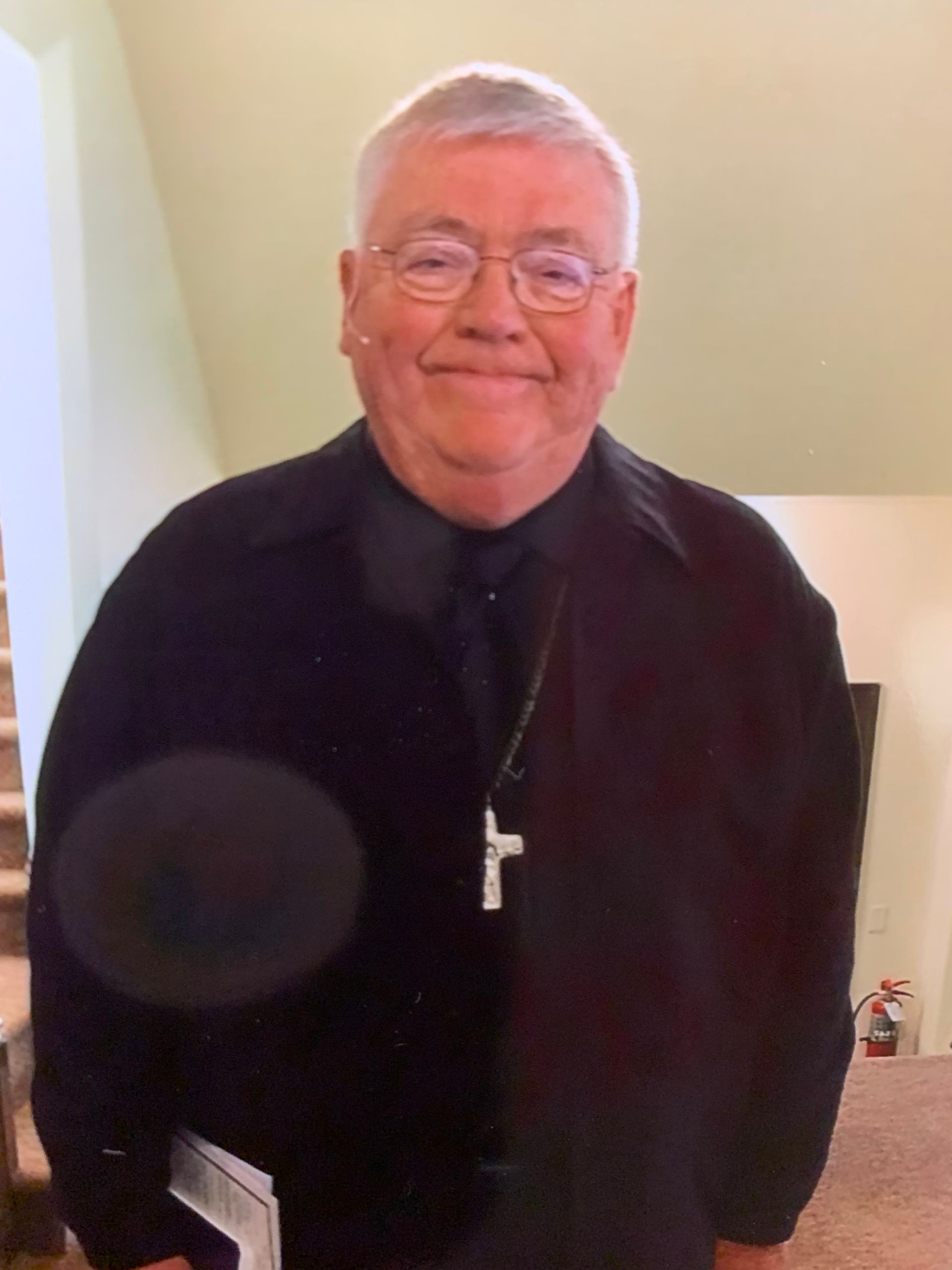 A man with glasses and a cross around his neck