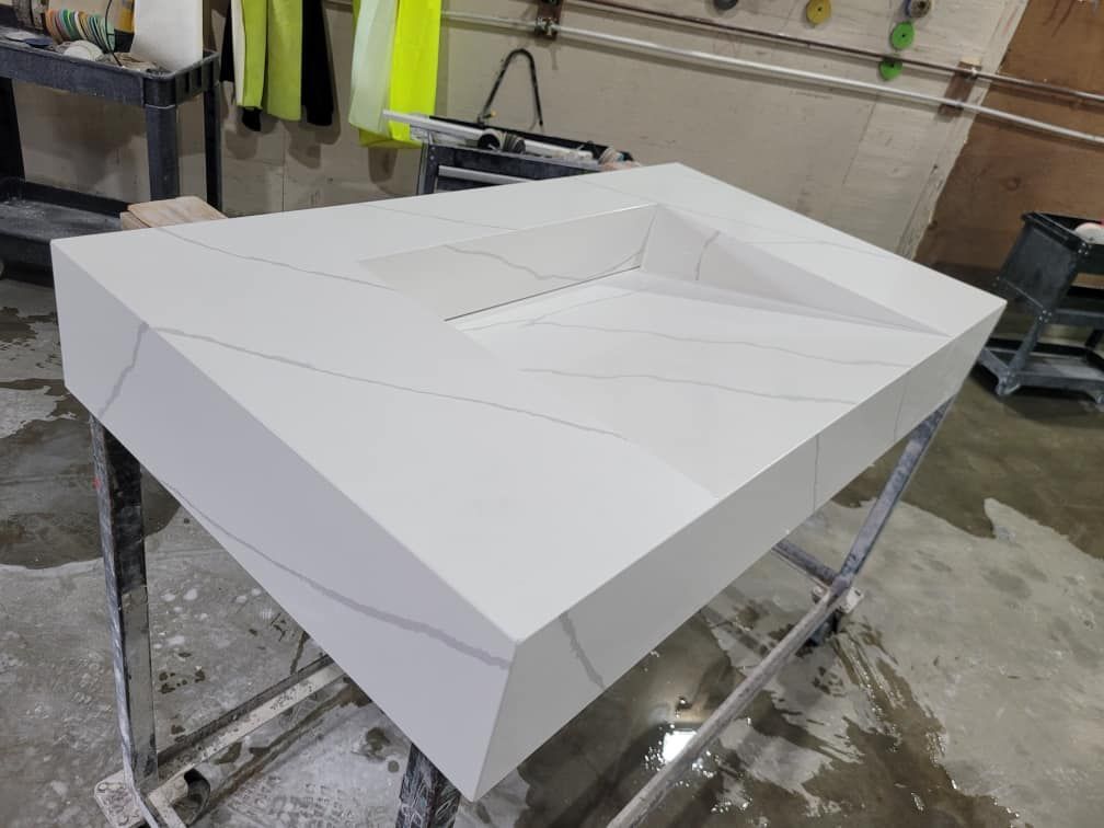 White quartz countertop with integrated basin, angled design.