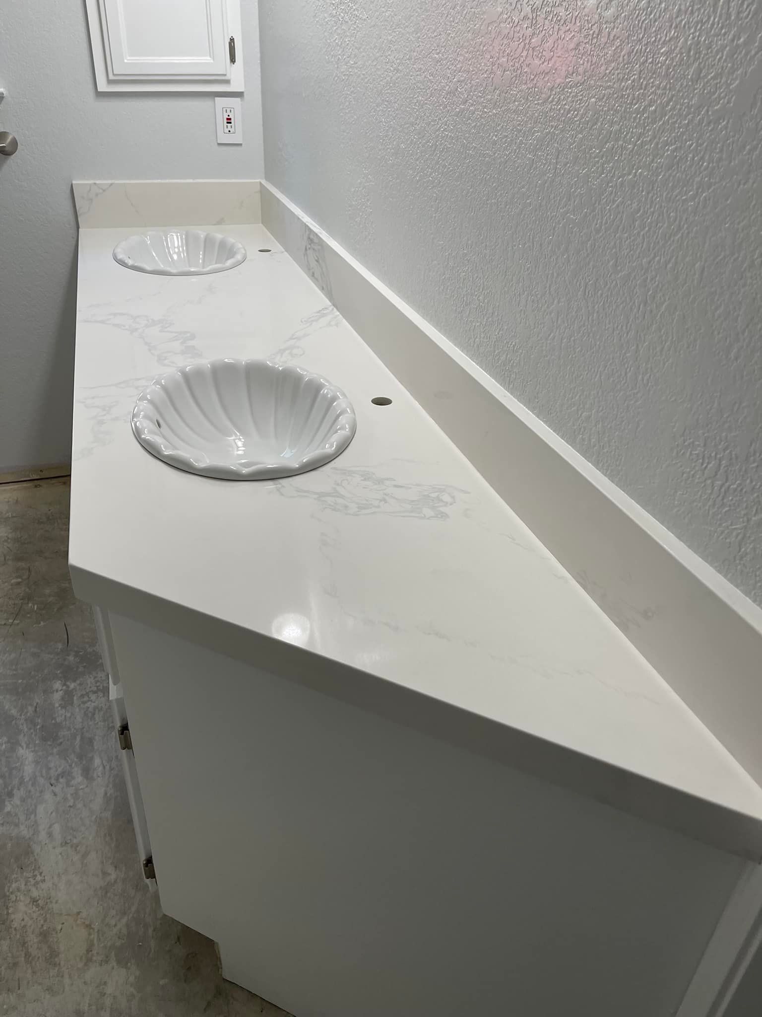 White bathroom vanity with two sinks; quartz countertop, white cabinet.