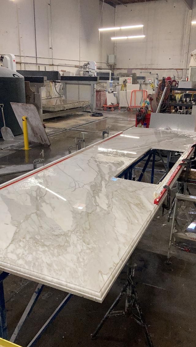 Marble countertop with sink cutout in a workshop setting.