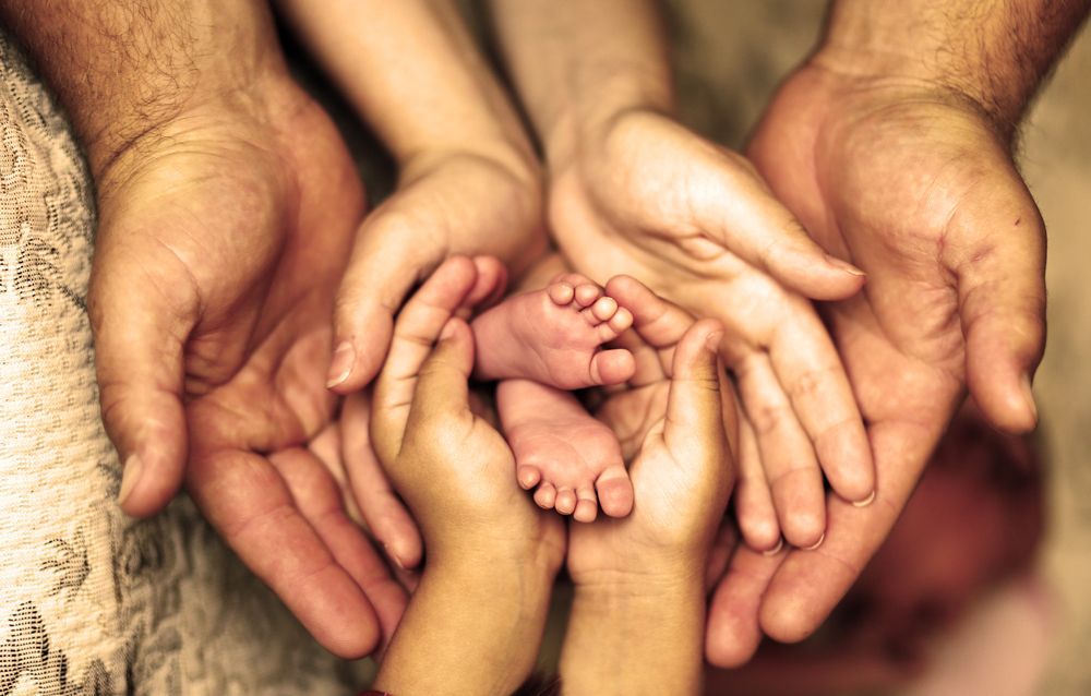 Hands of Adults and Children Cradle a Baby's Tiny Feet; Family — Amanda Jade Photography In Atherton Tablelands, QLD