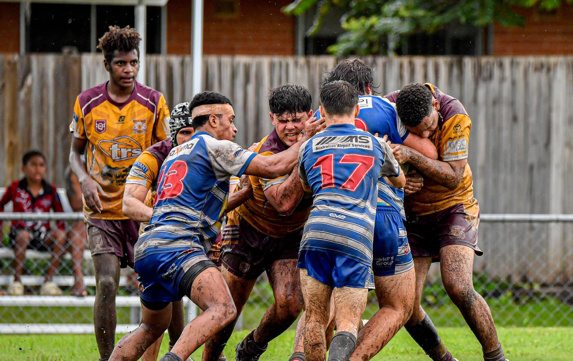 Rugby Players in Muddy Uniforms Locked in a Scrum on a Grassy Field — Amanda Jade Photography In Gordonvale, QLD