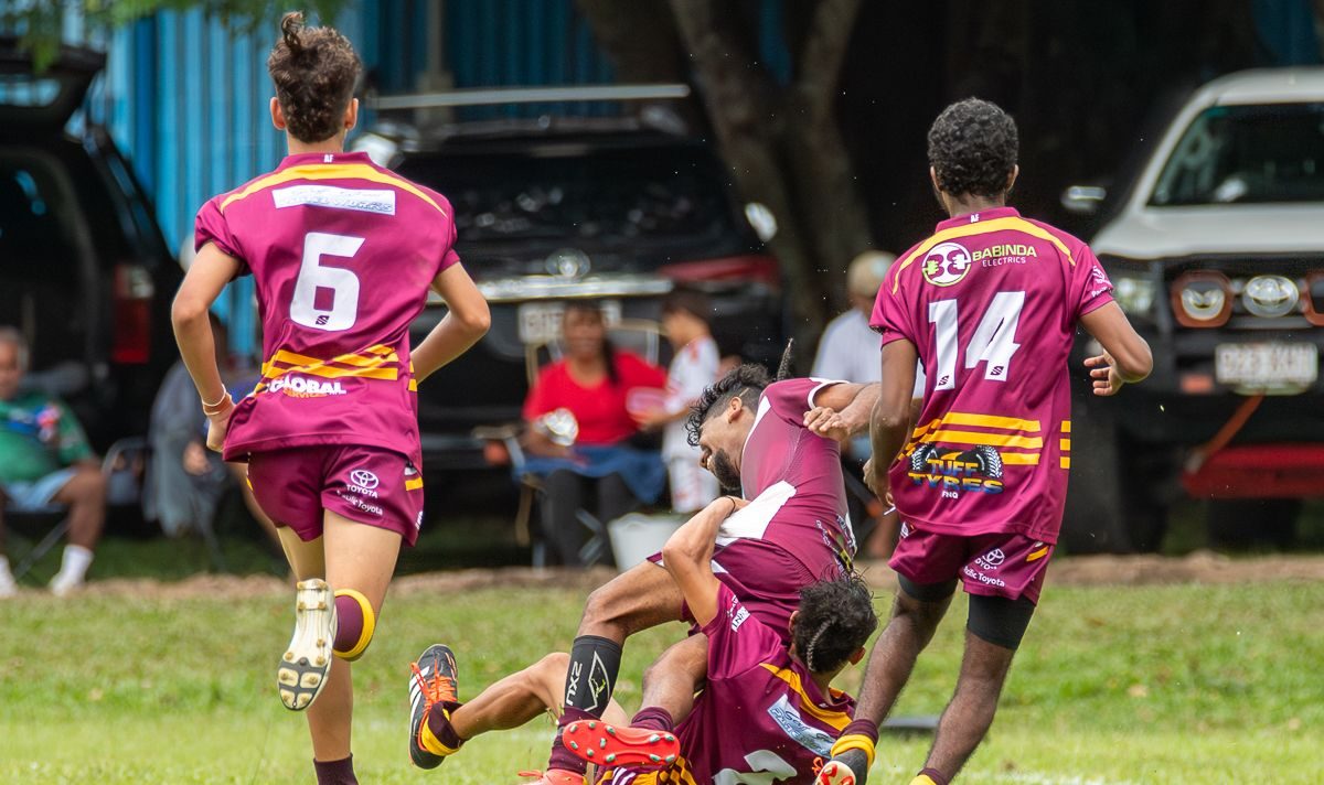 Rugby Player In Maroon Kicks The Ball Towards Goalposts On A Field — Amanda Jade Photography In Gordonvale, QLD