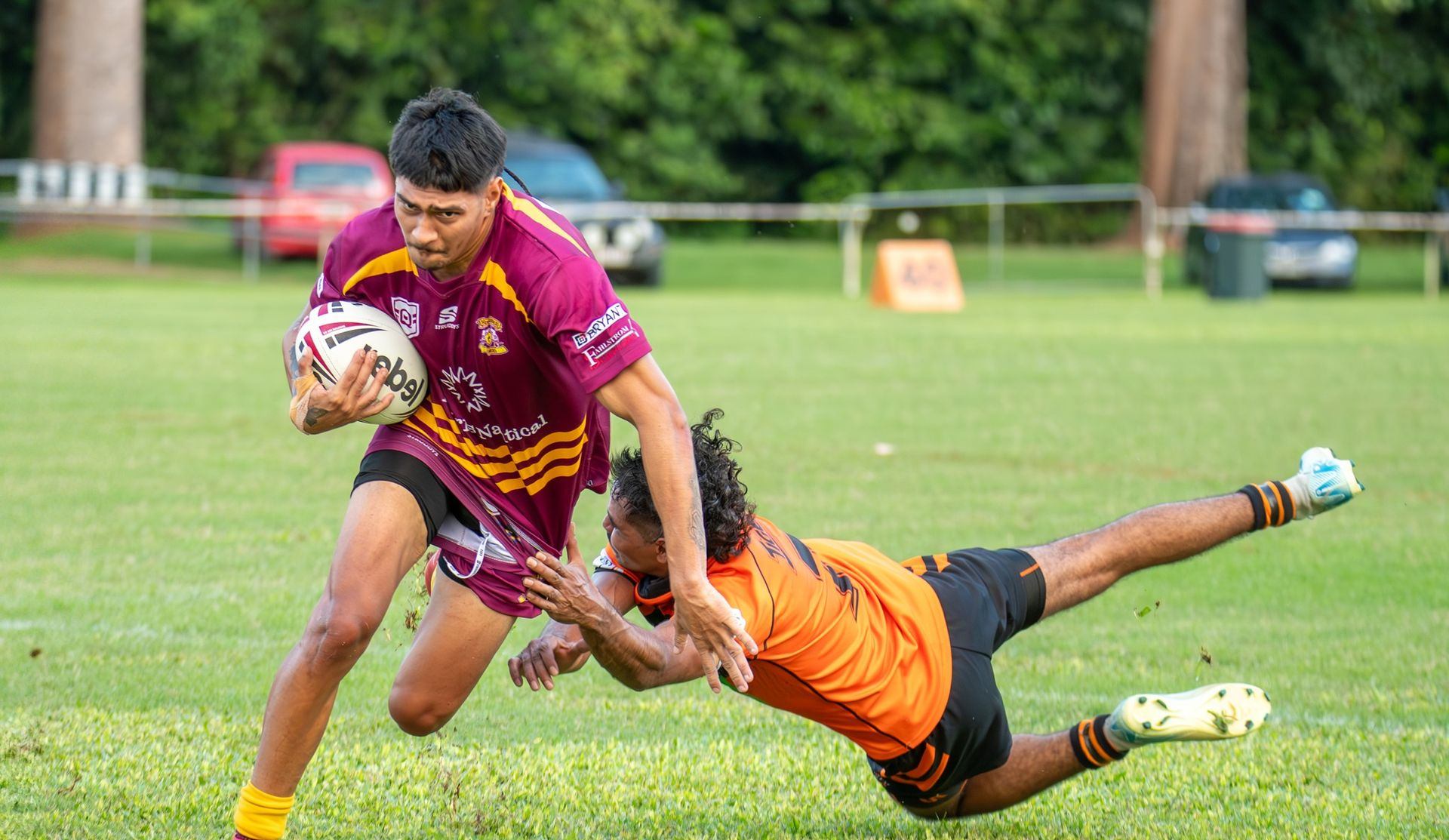 Rugby Player In Maroon Jersey Runs With Ball, Tackled By Player In Orange Jersey — Amanda Jade Photography In Gordonvale, QLD