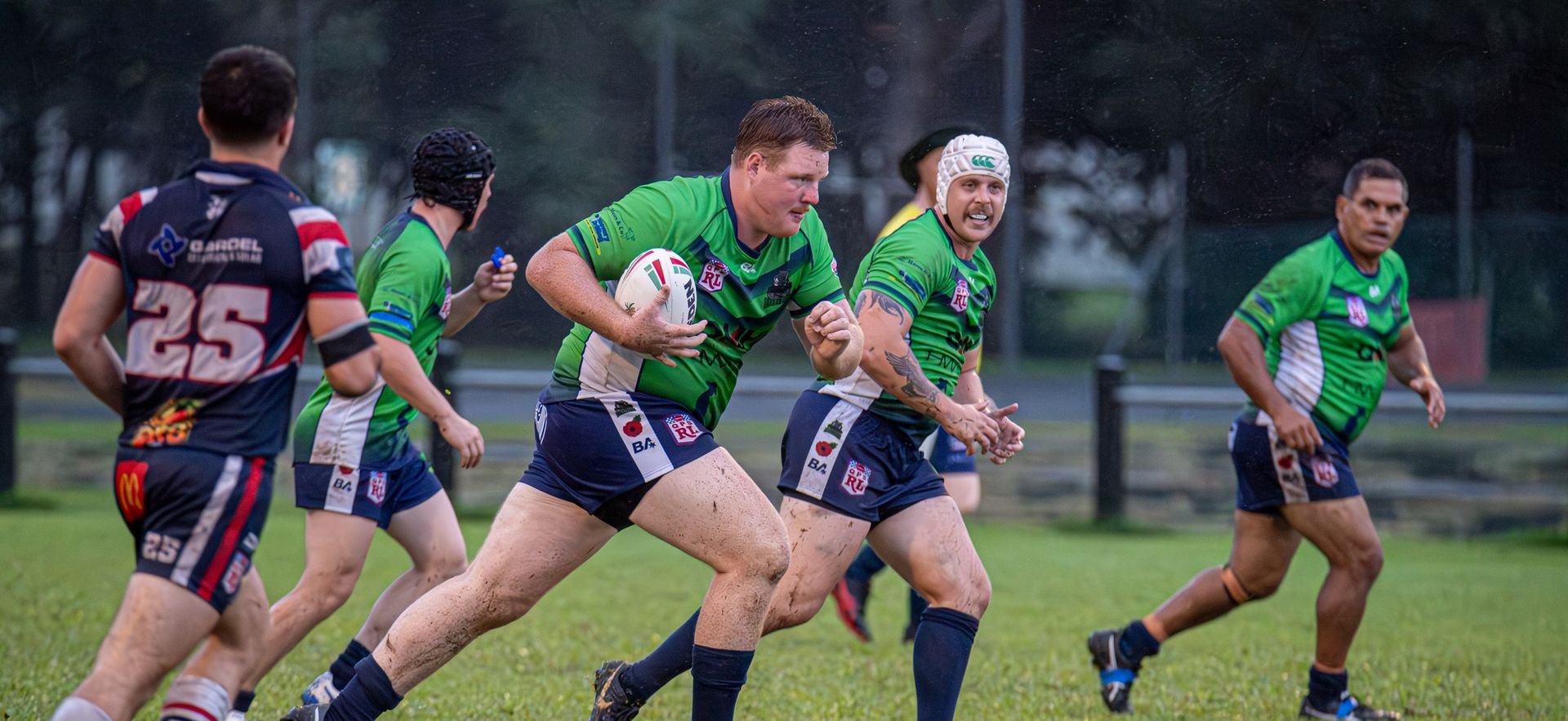 Rugby Players In Green Jerseys Run On A Muddy Field — Amanda Jade Photography In Port Douglas, QLD