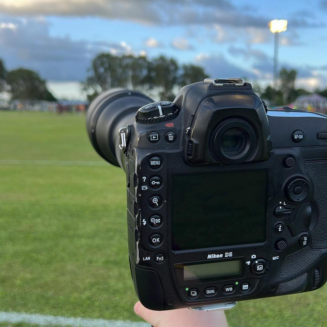 Camera With Long Lens At A Sports Field, Focusing On A Game — Amanda Jade Photography In Gordonvale, QLD