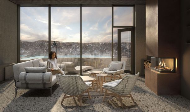 Woman relaxing in a modern room with a view of a snowy landscape, seating area with a fireplace.